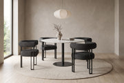 Mathilde black bouclé barrel dining armchair with black metal legs in a calm, daylit dining room