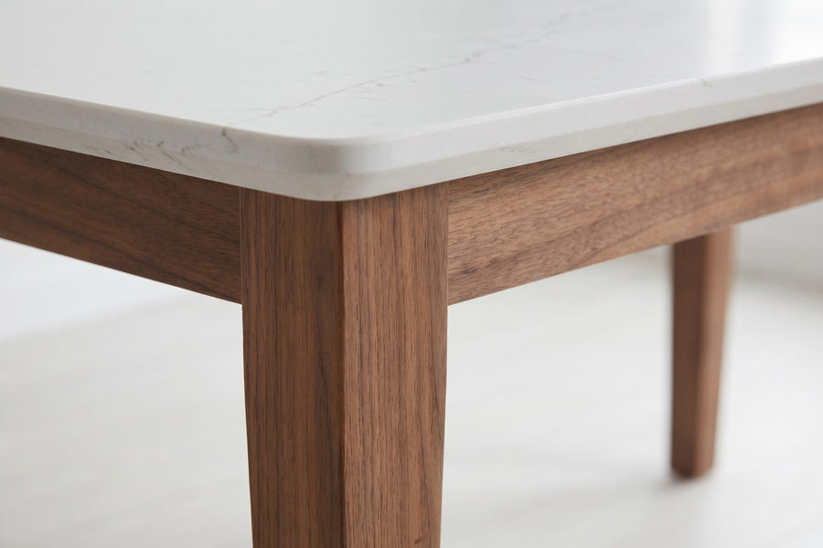 Ménerbes White Quartz and Walnut Dining Table: close-up of where a square tapered walnut leg meets the recessed apron under the quartz top