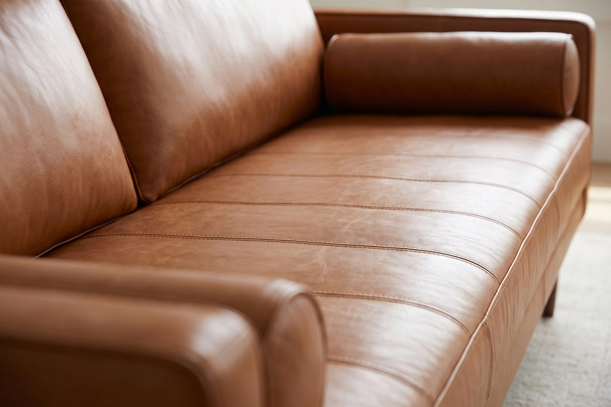 Menton 88" Cognac Leather Bench-Seat Sofa: close-up of the cognac leather bench seat, showing the fine stitched channels, the leather grain and its soft sheen