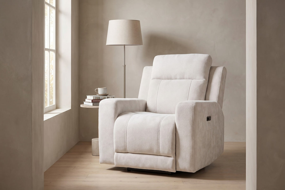 Daylight. Beside a reading lamp, the padded headrest and wide arms invite a long read.