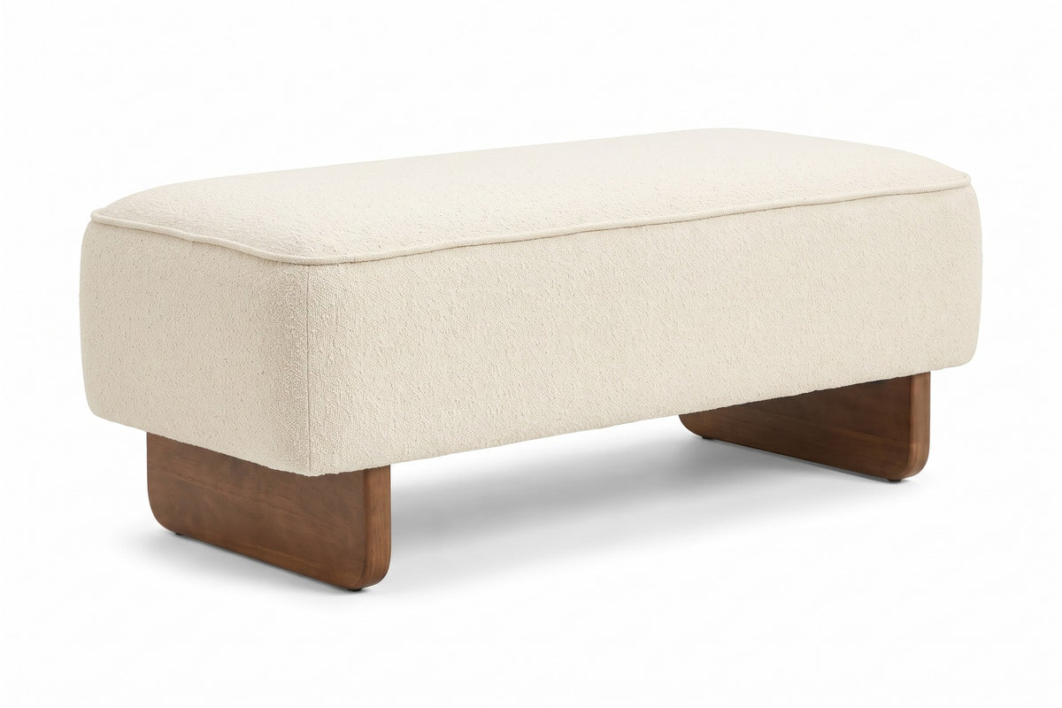 Montsouris 56.5" cream upholstered ottoman bench on rounded rubberwood legs, three-quarter view on a white background