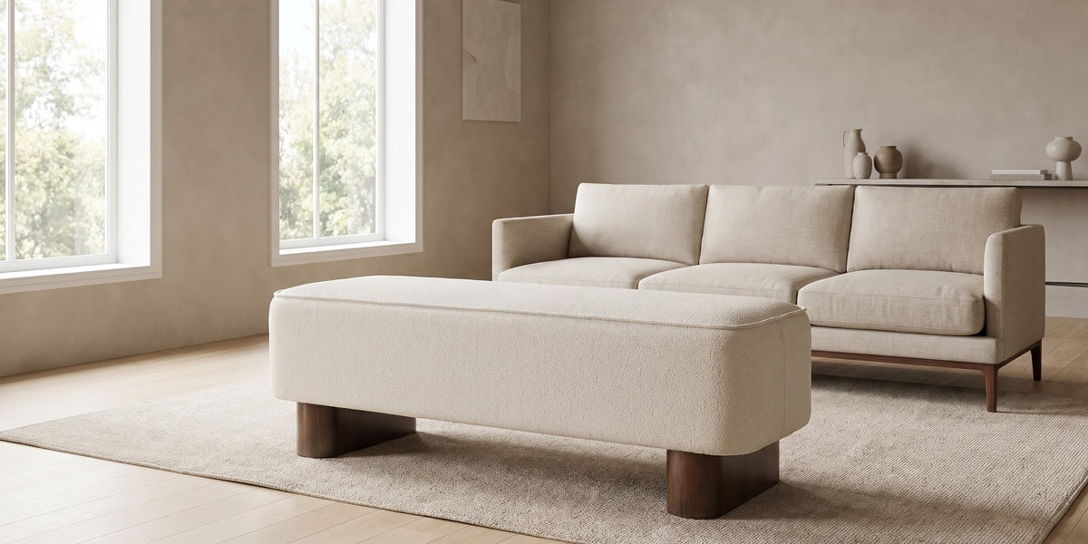 Montsouris 56.5" cream upholstered ottoman bench on rounded rubberwood legs in a wide room view