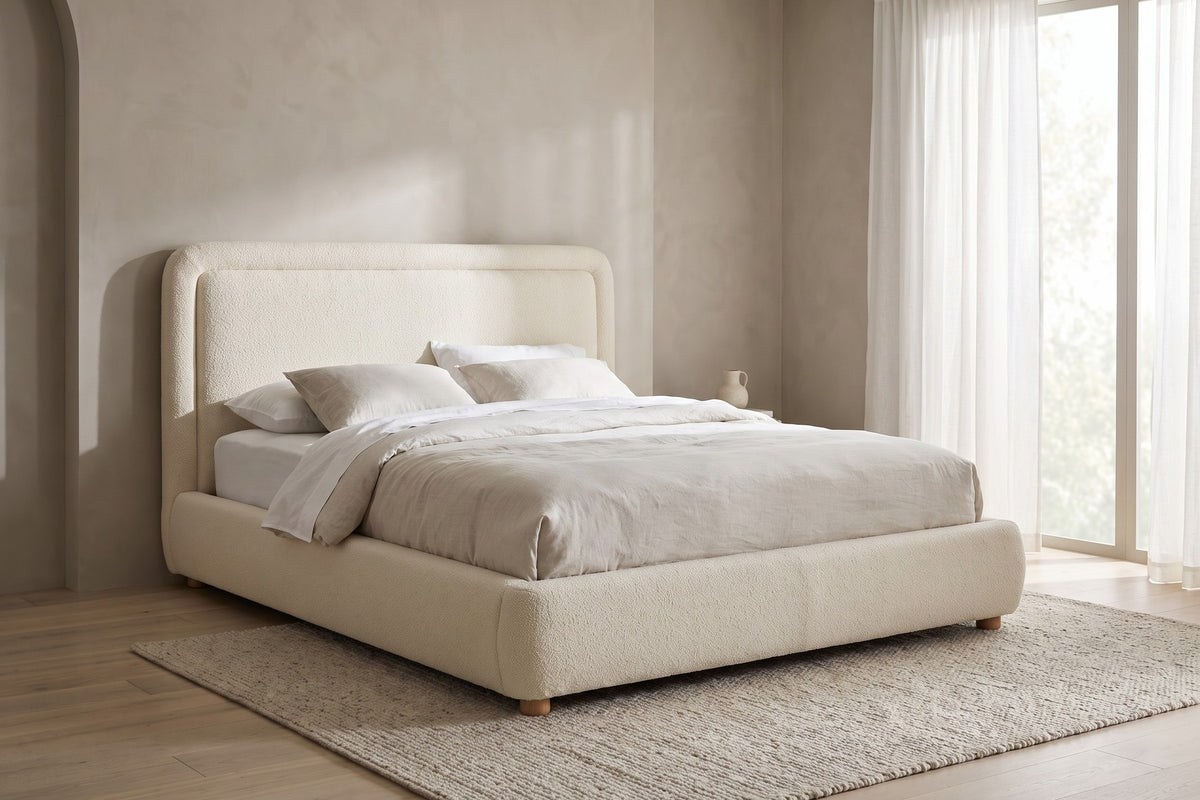 Nina beige-white bouclé platform bed with a rounded headboard in a calm, daylit bedroom