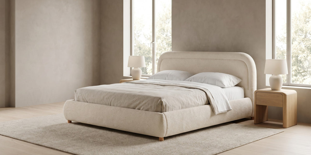 Nina beige-white bouclé platform bed with a rounded headboard in a wide, calm bedroom