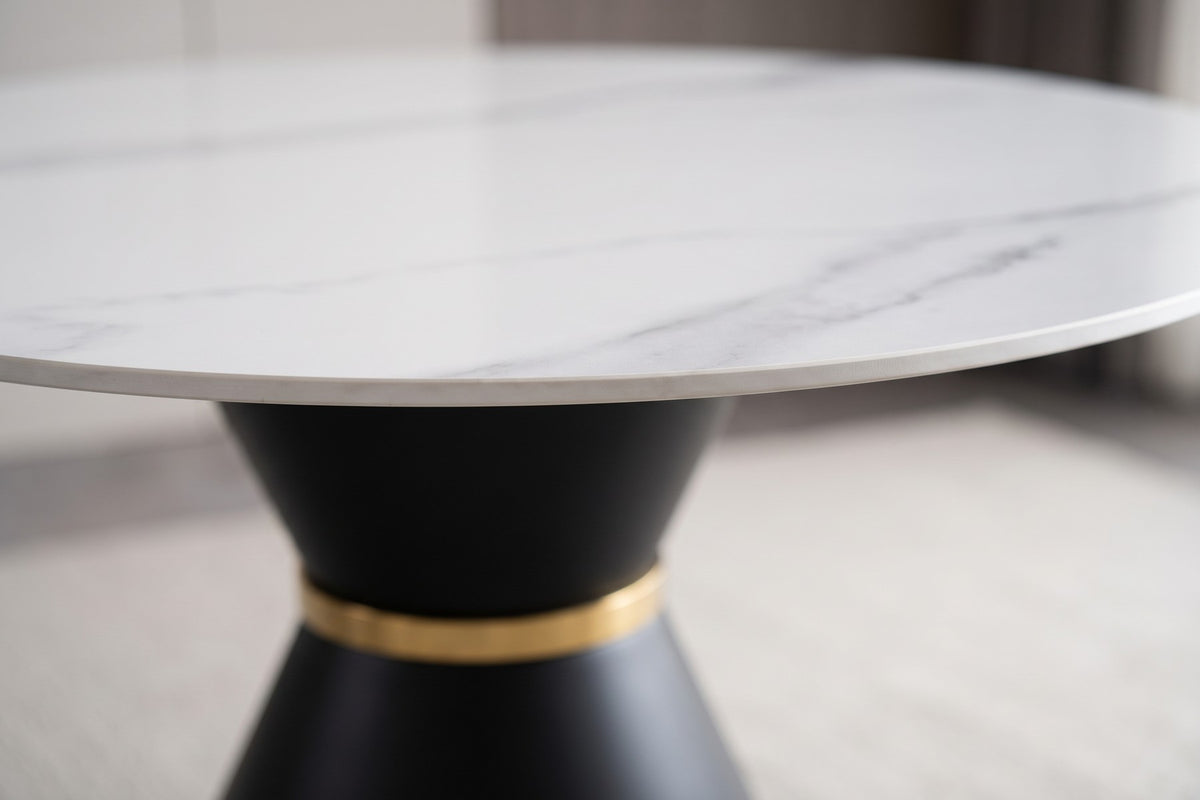 Close-up of the Orsay table's white sintered stone top and the gold-tone band on the black pedestal