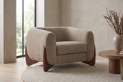 Passy light brown bouclé tuxedo accent chair with sculpted walnut-finish legs in a calm, daylit living room