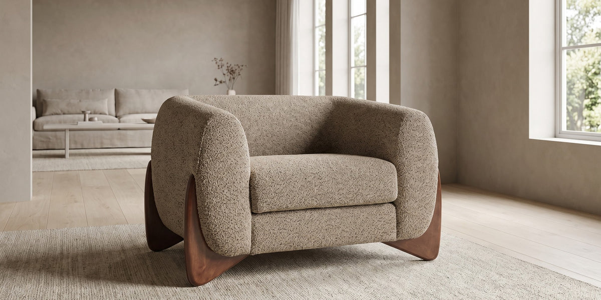 Passy light brown bouclé tuxedo accent chair with sculpted walnut-finish legs in a wide, calm living room
