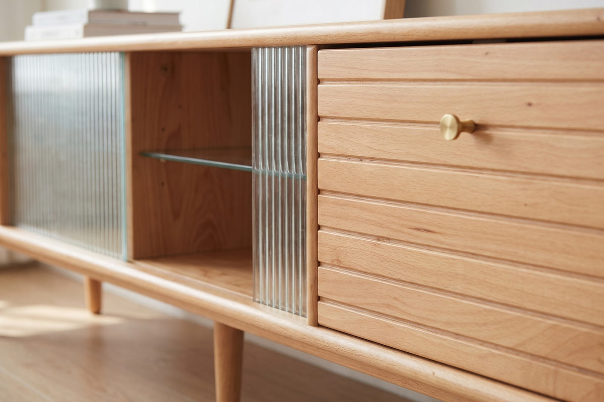 Close-up of a fluted glass door meeting the grooved beech drawer front with its small brass-tone knob (Rosalie)