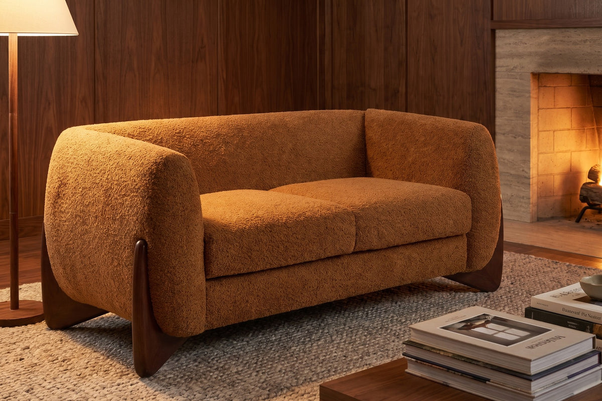 Evening. By the fire, the caramel bouclé glows against walnut panelling.