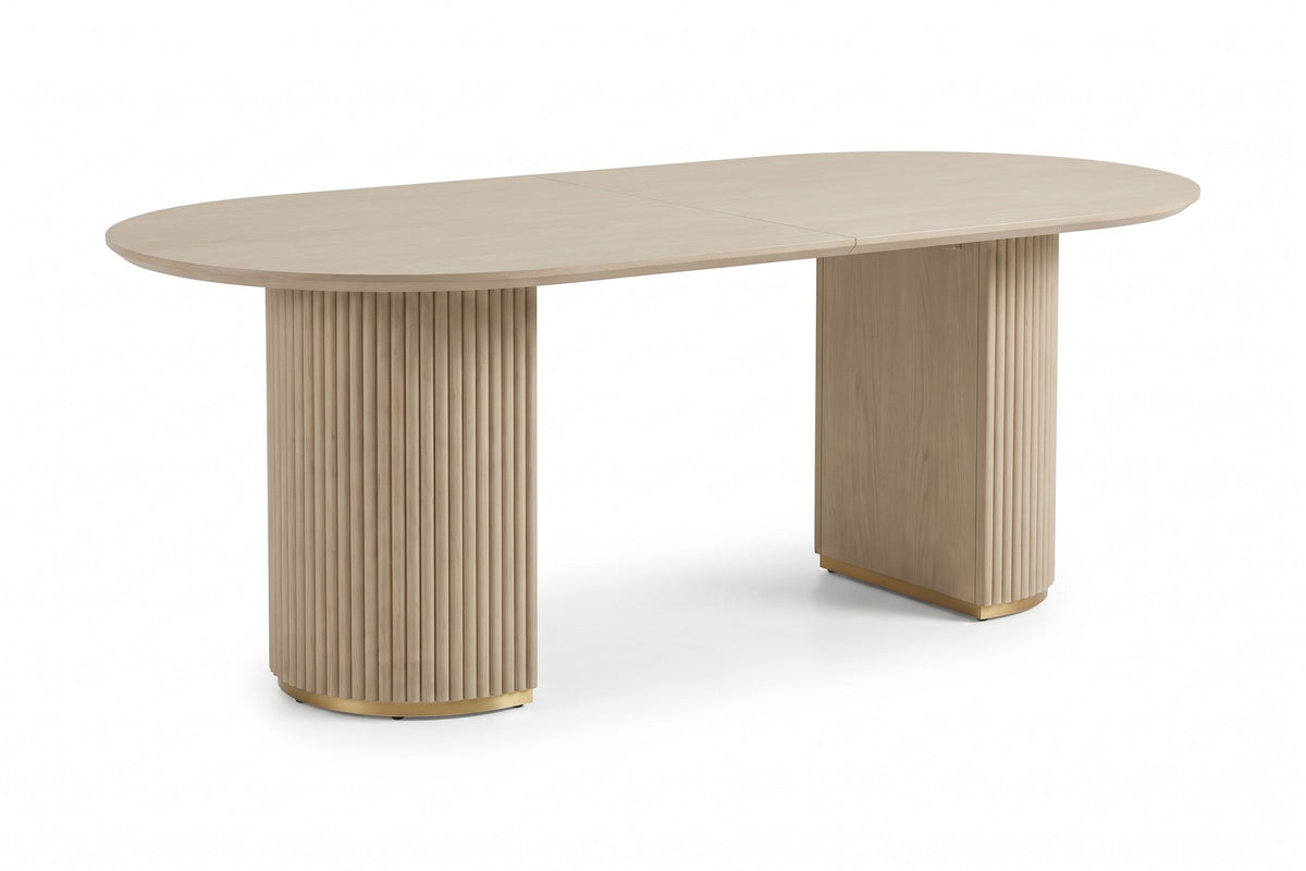 Tuileries 88-inch oval dining table with two fluted pedestals in a light natural finish, three-quarter view from slightly above, showing the oval top and both pedestals on a white background