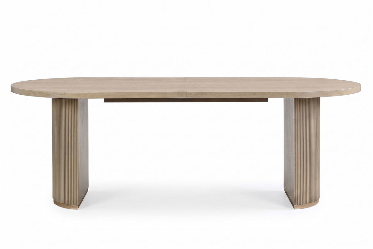 Tuileries 88-inch oval dining table with two fluted pedestals in a light natural finish, straight front view along the long side, at table height on a white background