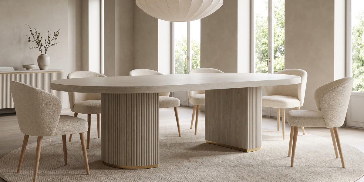Tuileries 88-inch oval dining table with two fluted pedestals in a light natural finish in a wide, calm dining room