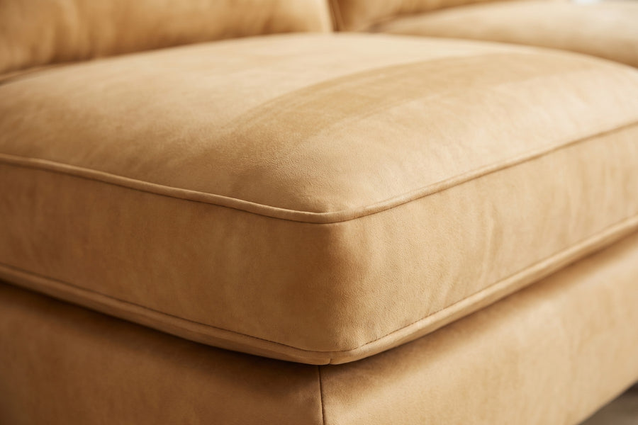 Uzès Camel Armless Nubuck Leather Sofa: close-up of a camel nubuck seat cushion corner, showing the velvety nap, the fine welt and a soft brushed streak in the nap