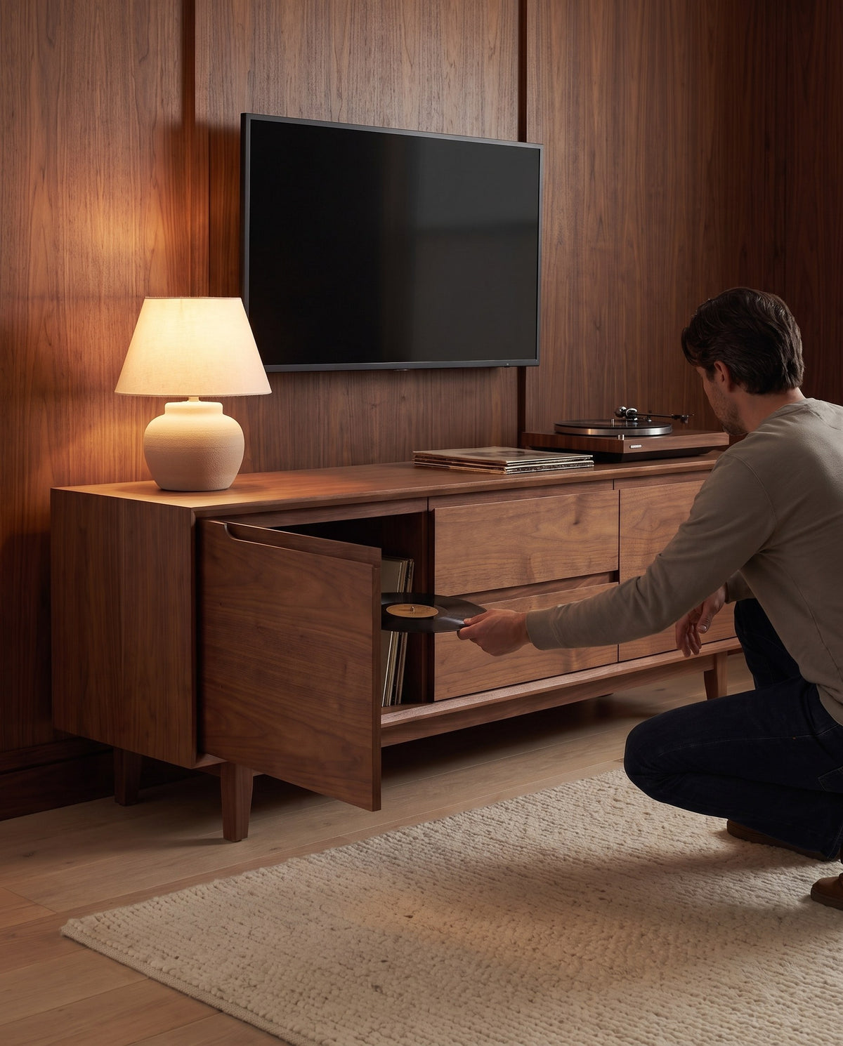 A person taking a record from behind a door of the Valence walnut console (concept image)