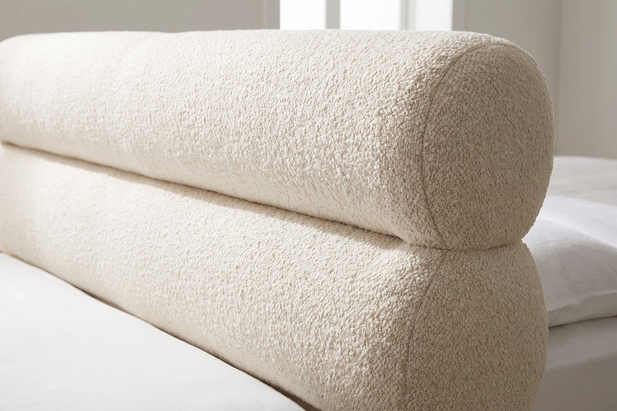 Valloire Ivory Bouclé Bed: close-up of the two stacked ivory bouclé headboard rolls and the soft crease between them, showing the looped texture