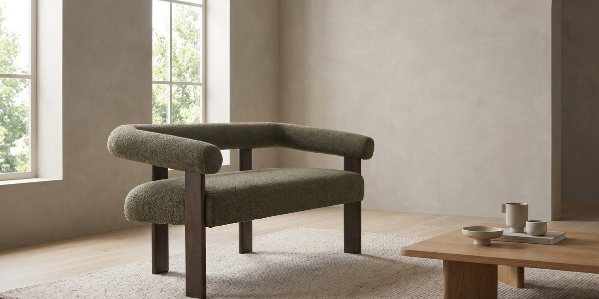Victoire 53.25" green bouclé loveseat with round bolster arms in a wide room view